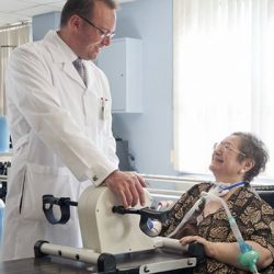 Doctor checking up on ventilated patient with a PMV007 inline